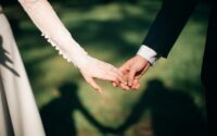A woman and man holding hands on their wedding day