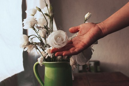 Hand showing appreciation for the gift of white flowers