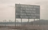 A sign by the road with some of the ten commandments