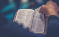 A man reading the Bible and turning pages