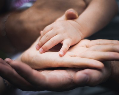 A child's hand on top of   the parent's hands